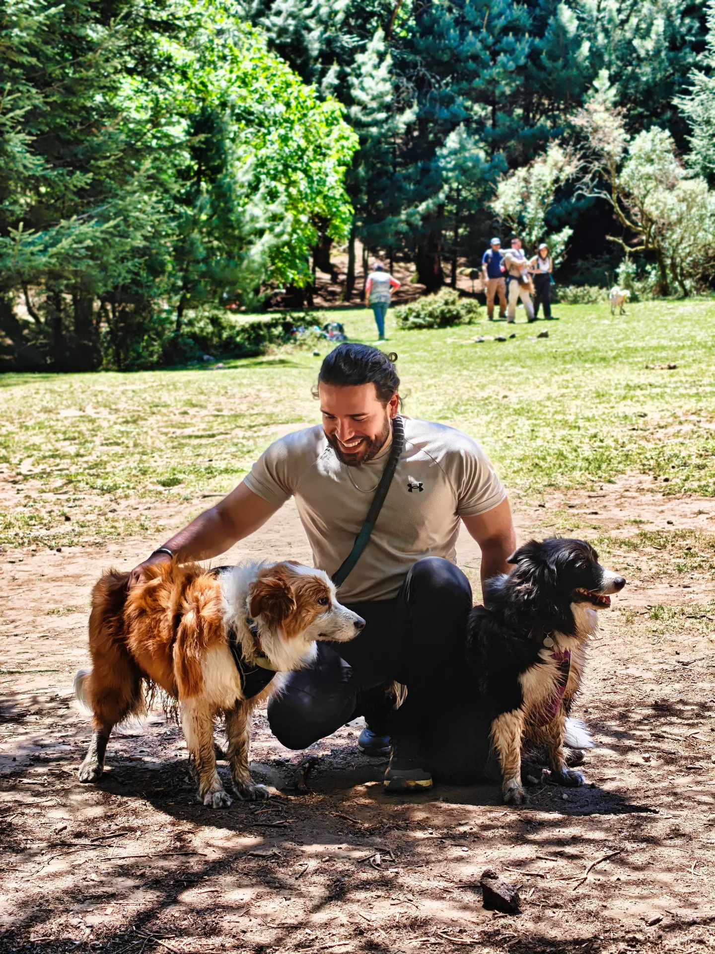 Sadok Cervantes in a park with his two dogs