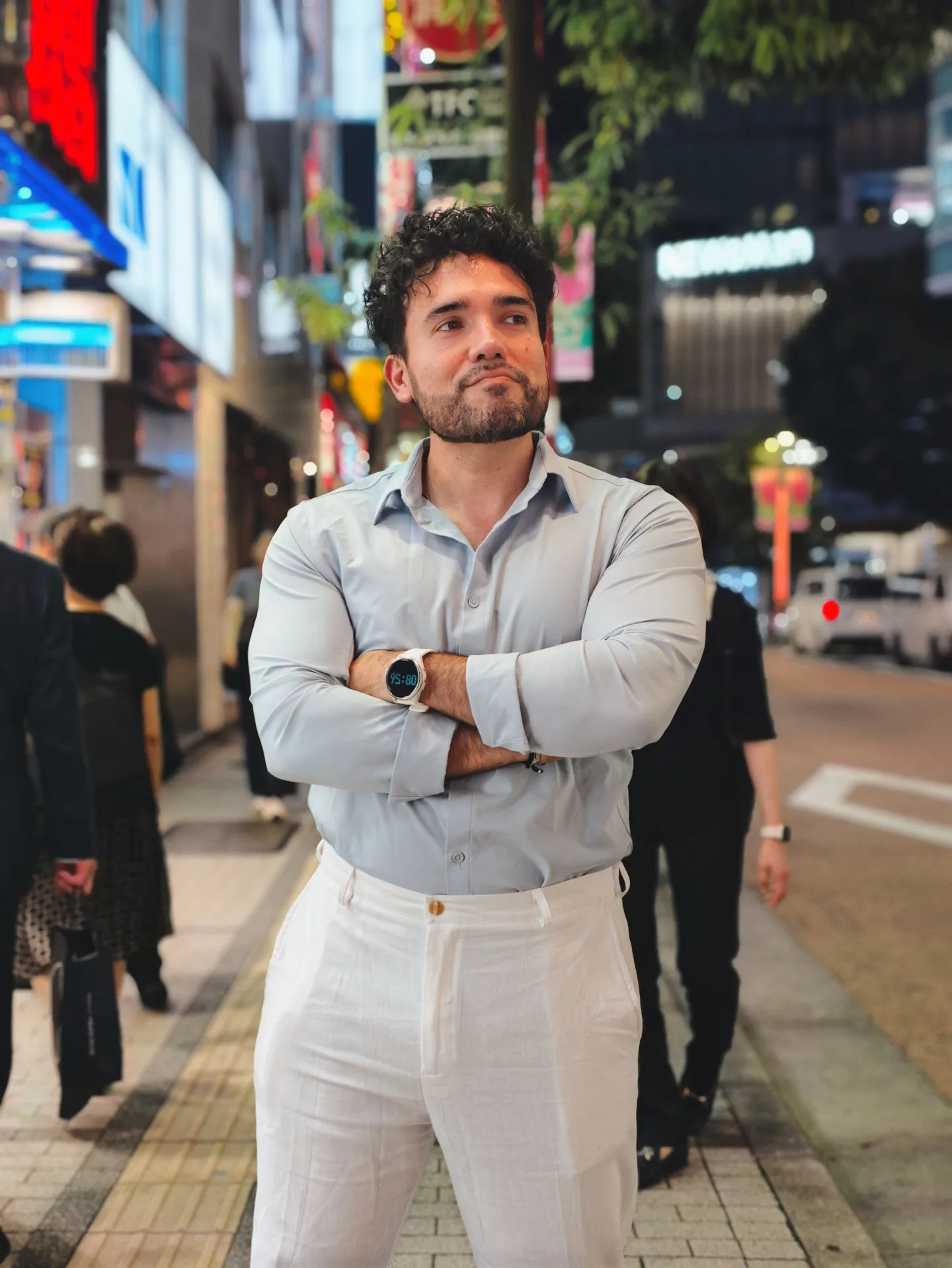 Sadok Cervantes on a city street at night, arms crossed
